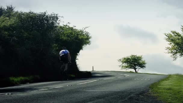 Cycliste monte la colline avec voiture Passing — Video