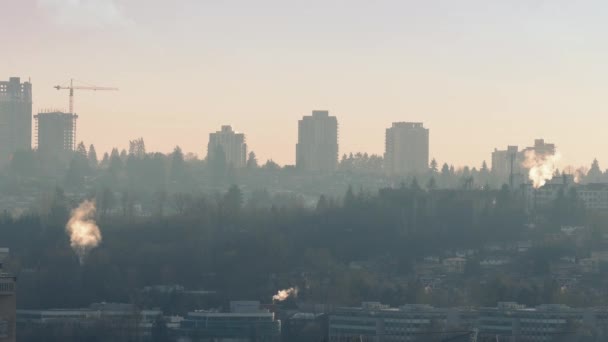 El humo se levanta de las chimeneas en la ciudad de la tarde — Vídeos de Stock