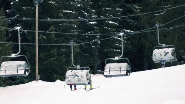 Лыжники на подъёмнике с отвисшими ногами — стоковое видео
