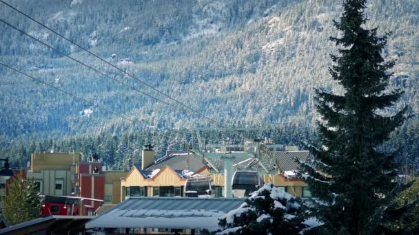 Ski Lift passerar ovanför bergsstad — Stockvideo