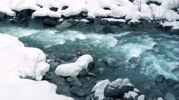 Ледяная голубая горная река в снегу — стоковое видео