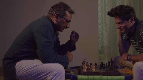 Father and Son playing chess, feeling happy in India. — Stock Video