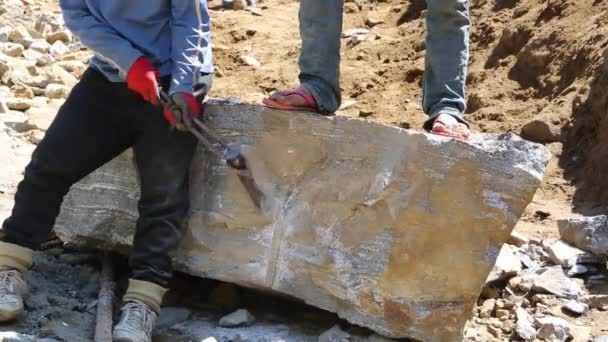 Ludzie używający dłuta i młotka do rozbicia skały — Wideo stockowe