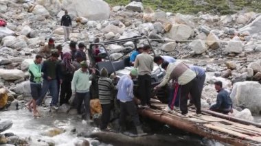  Araç nehirdeki dar köprüden geçiyor..