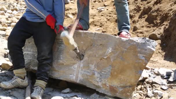 Ludzie używający dłuta i młotka do rozbicia skały — Wideo stockowe