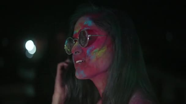 Tančící mladá indická žena se suchým barevným práškem Holi explodující kolem ní — Stock video