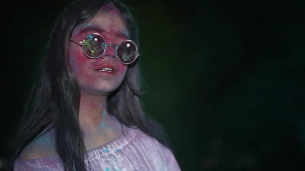 Dancing young Indian woman with dry color powder Holi exploding around her — Stock Video