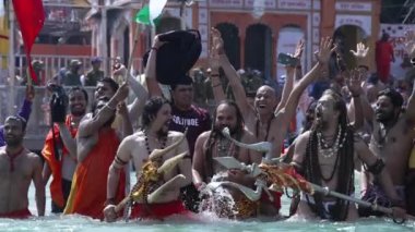 Kumbh Mela Haridwar Hindistan. Sadhus 'un ya da Akharas Azizleri' nin Ganj Nehri 'nin Kutsal Suyu' nda banyo yaptığı yavaş çekim. Trishul ve Shank süsüyle ibadet et. Appleprores 422 Cinetone