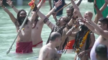 Kumbh Mela Haridwar Hindistan. Sadhus 'un ya da Akharas Azizleri' nin Ganj Nehri 'nin Kutsal Suyu' nda banyo yaptığı yavaş çekim. Trishul ve Shank süsüyle ibadet et. Tiranga 'yı açın. Appleprores 422 Cinetone