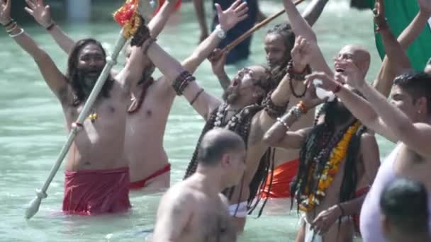 Kumbh Mela Haridwar Indie. Zpomalený záběr Sadhusa nebo svatých z Akharasu, jak se koupe ve Svaté vodě řeky Gangy. Uctívání s Trishul a Shank ornament. Rozviňte Tirangu. Appleprores 422 Cinetone — Stock video