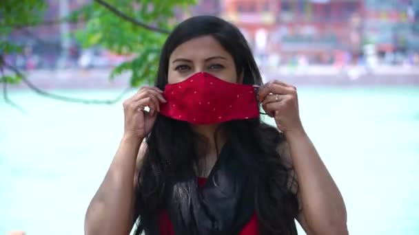 Ινδή γυναίκα φορώντας Coronavirus μάσκα προσώπου προστασία Ιερό ποτάμι Γάγγη ρέει στο παρασκήνιο, Haridwar Uttarakhand Ινδία, Appleprores 422 Cinetone 4k — Αρχείο Βίντεο