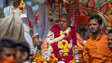 Hint sadhusu Kumbh Mela 'ya geliyor, Royal Welcome. Sadhus çelenk takarak oturuyor.