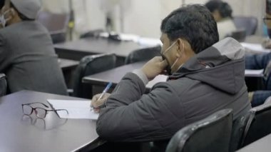 Sınıfta yüz maskesi takan Hintli öğrenciler. Uzun koronavirüs kilitlenmesinden sonra okul yeniden açılıyor.. 