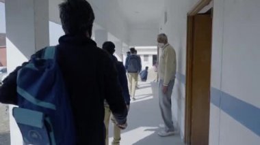 Sınıfta yüz maskesi takan Hintli öğrenciler. Uzun koronavirüs kilitlenmesinden sonra okul yeniden açılıyor.. 