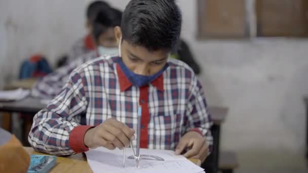 Étudiants indiens portant un masque facial en classe. L'école rouvre après un long confinement pour coronavirus. — Video
