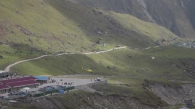 Hacıları taşıyan helikopterler, Kedarnath yakınlarındaki çayırlar, dinlenmek için hacılar için kulübeler.