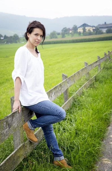 Country girl leaning on a fence — Stock Photo, Image