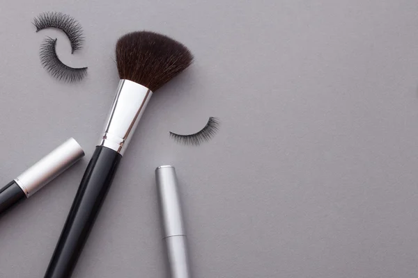 Hermoso maquillaje sobre un fondo gris . — Foto de Stock