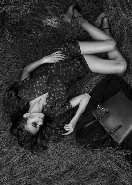 Fashionable girl with handbag on nature. — Stock Photo, Image
