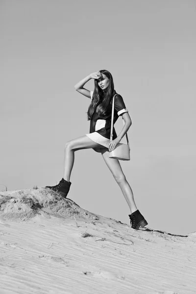 Creative shot in the desert. A beautiful sexy girl in a black dress. T — Stock Photo, Image