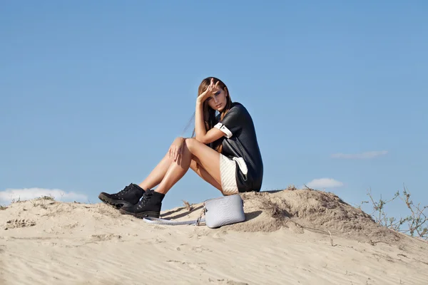 Um tiro criativo no deserto. Uma menina sexy bonita em um vestido preto. T — Fotografia de Stock