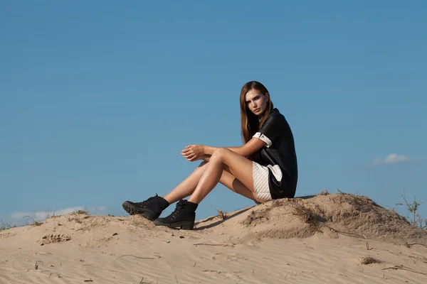 Um tiro criativo no deserto. Uma menina sexy bonita em um vestido preto. T — Fotografia de Stock