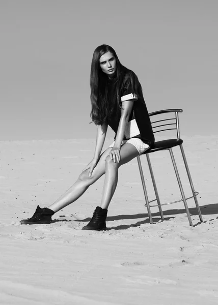 Creative shot in the desert. A beautiful sexy girl in a black dress. T — Stock Photo, Image