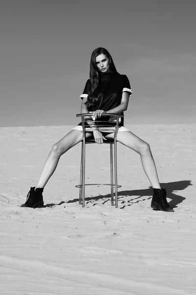 Um tiro criativo no deserto. Uma menina sexy bonita em um vestido preto. T — Fotografia de Stock