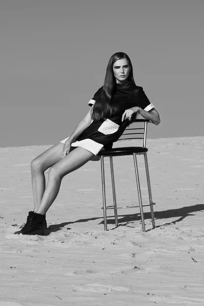 Creative shot in the desert. A beautiful sexy girl in a black dress. T — Stock Photo, Image