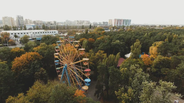 Ferris wheel attraction in the park in autumn from a height.