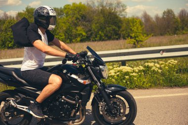 UKRAINE, KHARKIV - 22 Temmuz 2020: Şık motosikletçi siyah Suzuki spor bisikleti sürüyor.