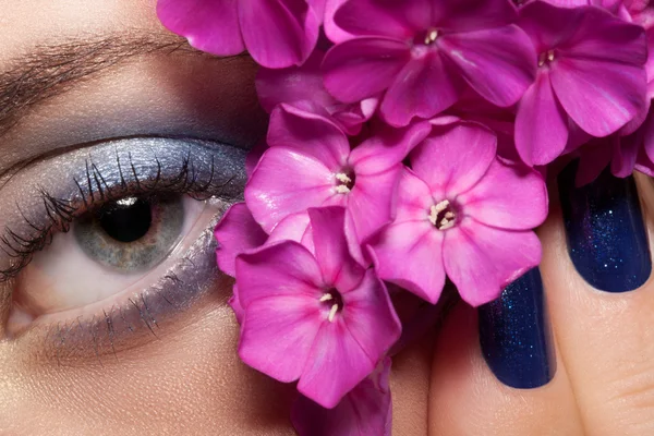 Vackra ögonmakeup och blommor. — Stockfoto