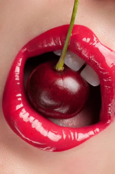 Rote Lippen mit einer Kirsche. — Stockfoto