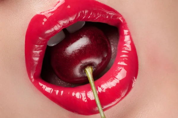 Rote Lippen mit einer Kirsche. — Stockfoto