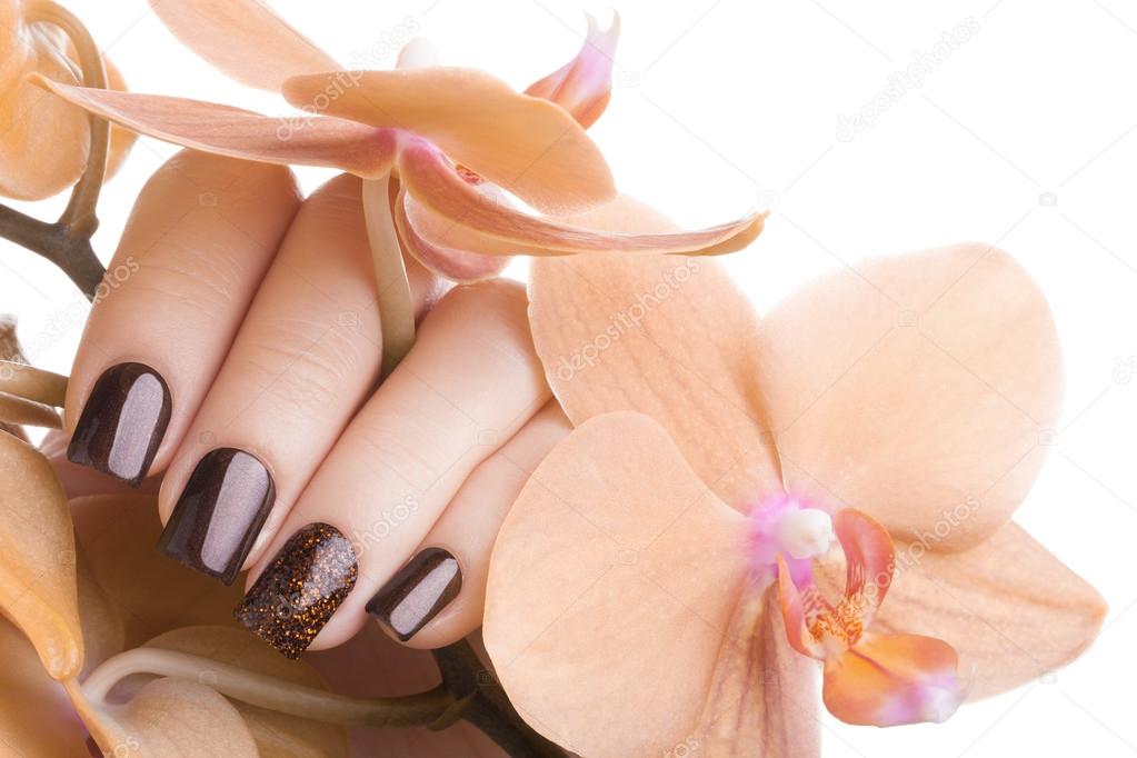 Brown nail polish on the nails.