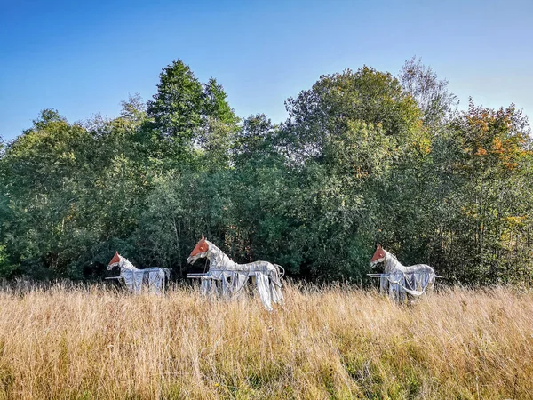 Horse sculptures grazing in the meadow