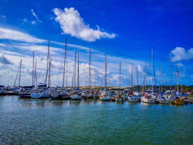 Litvanya 'daki Nida tatil köyünde yat marinası ve mavi gökyüzü ve berrak kristal su.