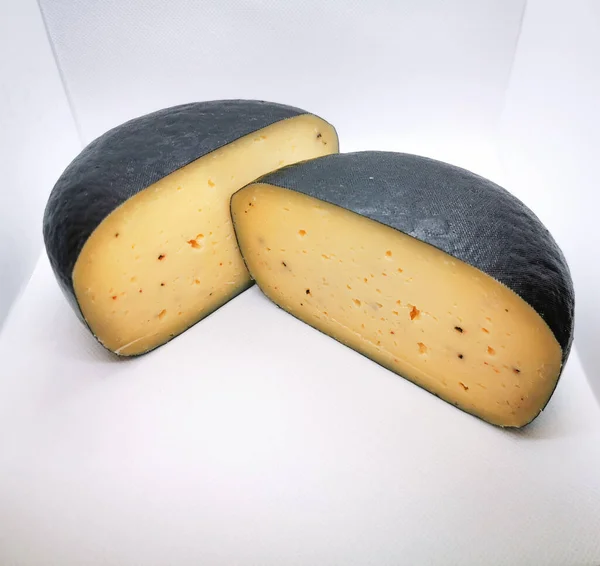 Ruota formaggio rivestita di cera tagliata in due pezzi foto scattata in un lightbox — Foto Stock