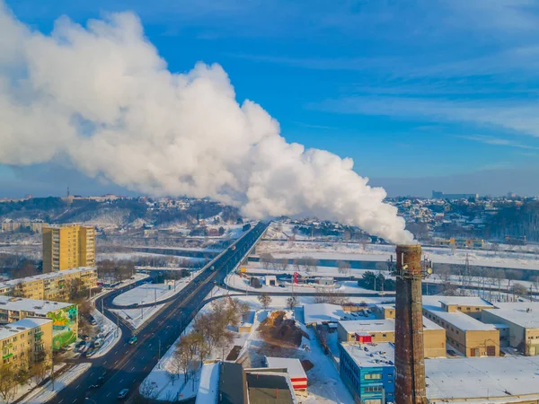 Pollution in a large city. White smoke coming from a huge industrial chimney