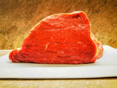 Kesme tahtasındaki taze kesilmiş kırmızı et parçası.