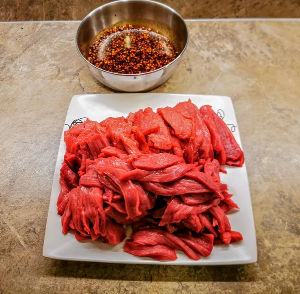 Freshly cut beef strips ready for marinade and making a beef jerky