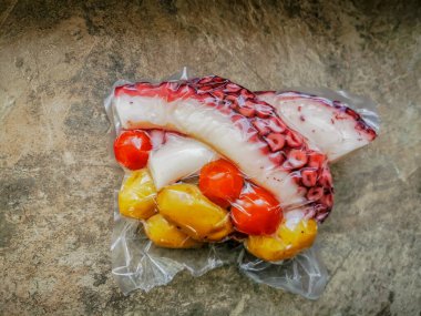 Haşlanmış ahtapot dokunaçları ve plastik bir torbaya konulmuş garnitür.