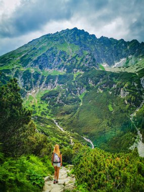 Büyük bir dağın önünde duran bir kız.
