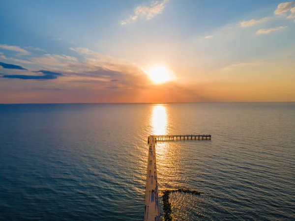 Vista aérea de un puente al mar y una puesta de sol en el horizonte — Foto de Stock