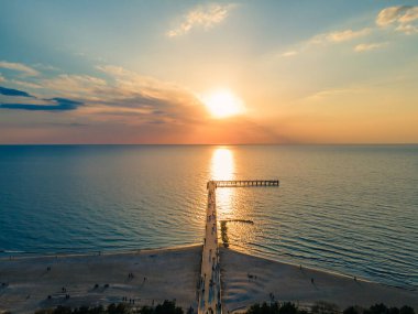 Palanga Köprüsü 'nün havadan görünüşü Baltık Denizi' ne doğru düz bir yol ve günbatımı