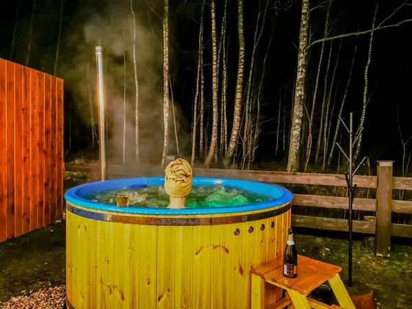 A menina está tomando banho e relaxando em uma banheira de hidromassagem à noite — Fotografia de Stock