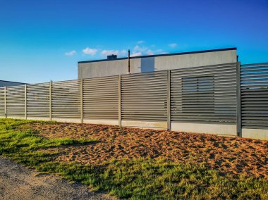 Yeni yapılmış tek katlı bir evin yakınındaki segmental çitin fotoğrafı.