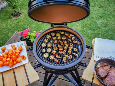 Büyük bir barbekü mangalı biftek ve sebze pişirmeye hazır.