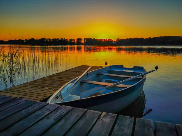 Foto de un barco vacío en el muelle del lago al atardecer — Foto de Stock