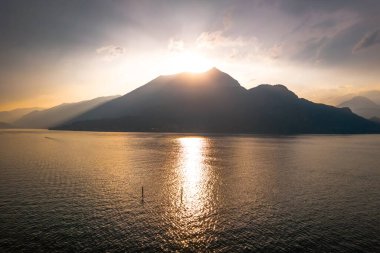 Como Gölü 'ndeki gün batımlı sisli dağların fotoğrafı